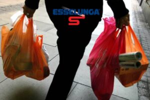 Un uomo con delle buste della spesa nelle mani con il logo di Esselunga