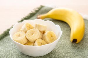 banana a pezzi in ciotola e intera sul tavolo
