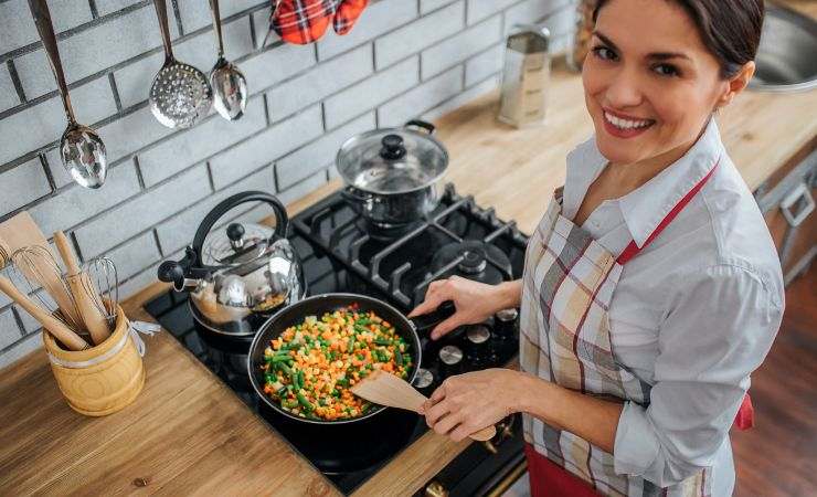donna sorridente ai fornelli 