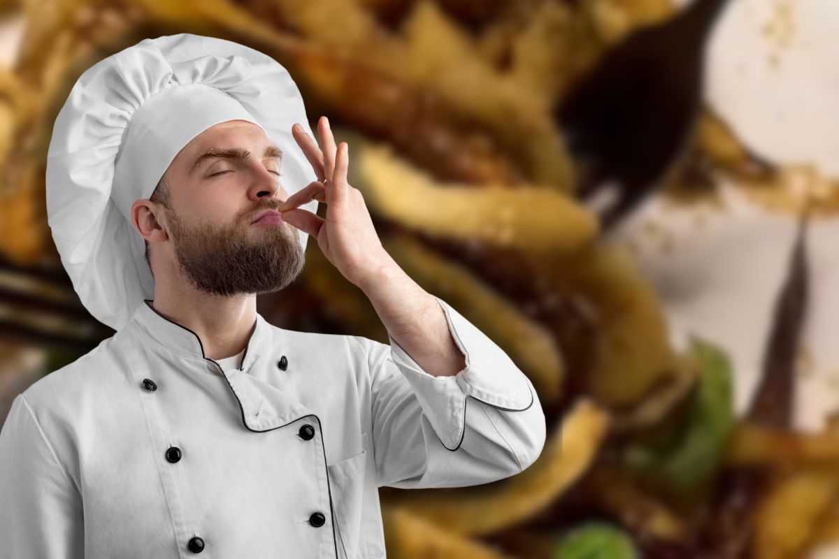 melanzane sabbiose sullo sfondo e chef che manda un bacio