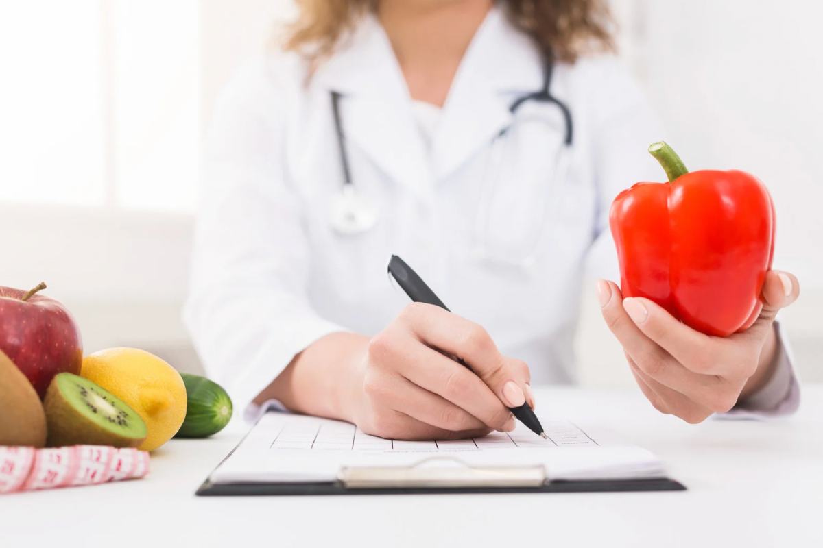 Donna con camice che scrive con peperone in mano