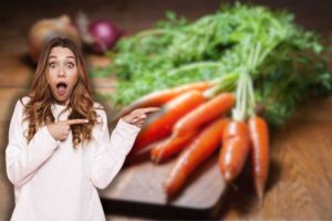 carote su tagliere di legno e donna sorpresa che le indica