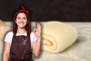 panetto di pasta sfoglia e mattarella su piano da lavoro e donna sporca di farina che fa ok con le mani