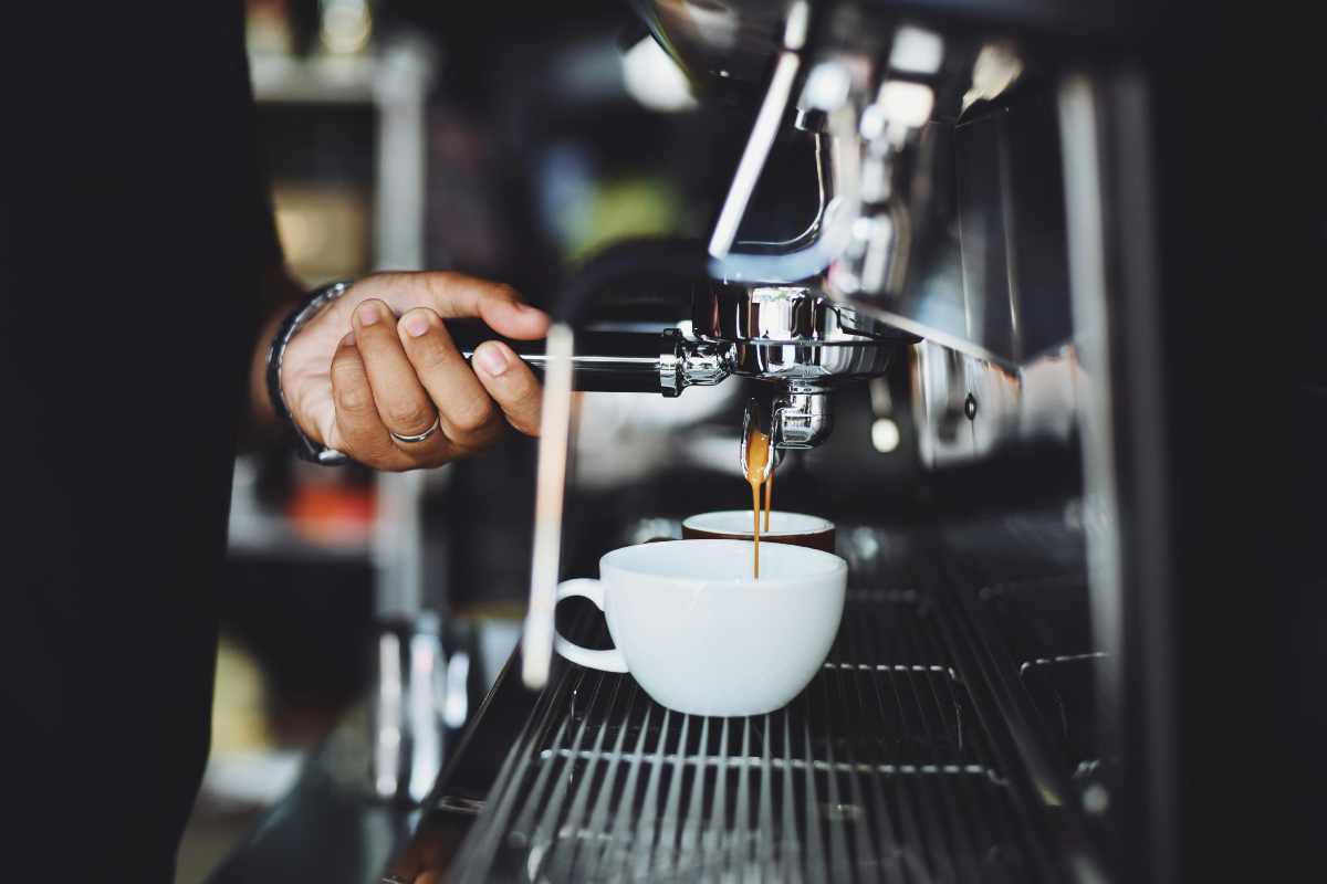 Un barista che prepara un cappuccino e un espresso