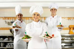 cuochi che cucinano e presentano piatti