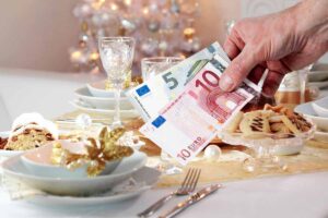 tavola imbandita per natale e mano che mantiene 15 euro