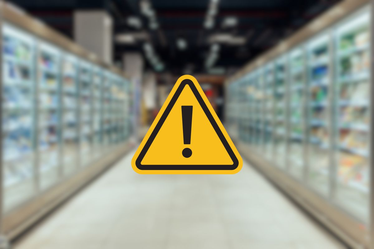 frigoriferi di un supermercato e segnale di pericolo