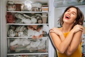 donna soddisfatta per il frigorifero pieno
