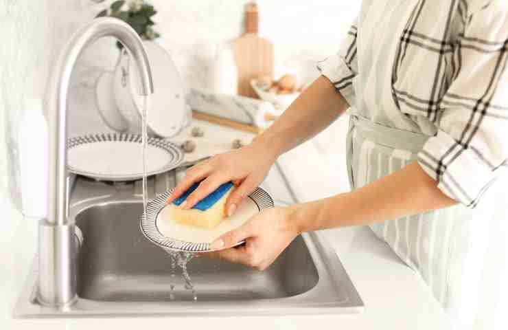 lavare piatti nel lavello della cucina
