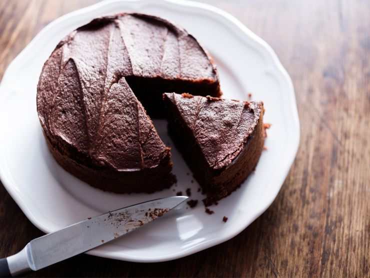 torta al cioccolato su piatto con una fettina tagliata a coltello