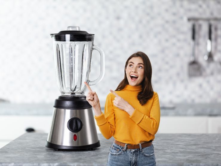 donna sorpresa che indica un frullatore pulito