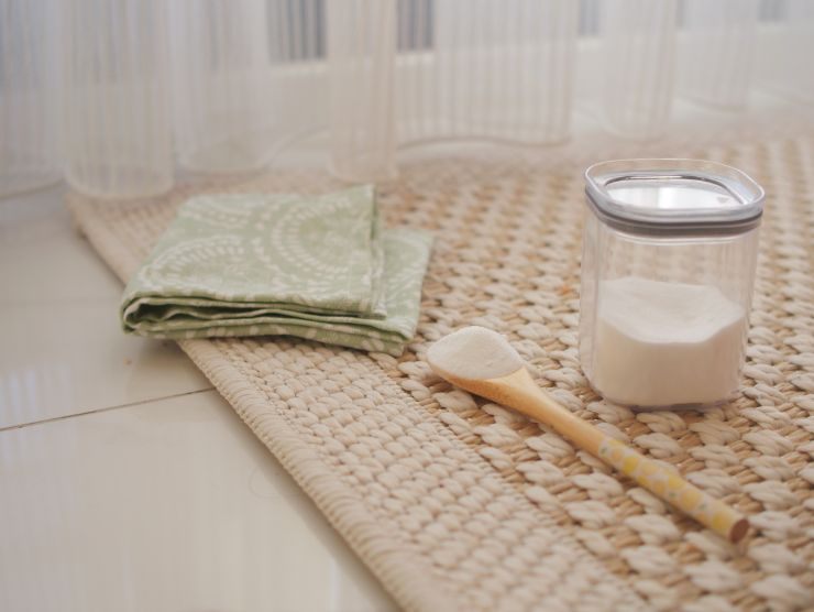 bicarbonato, panno e spazzola su un tappeto
