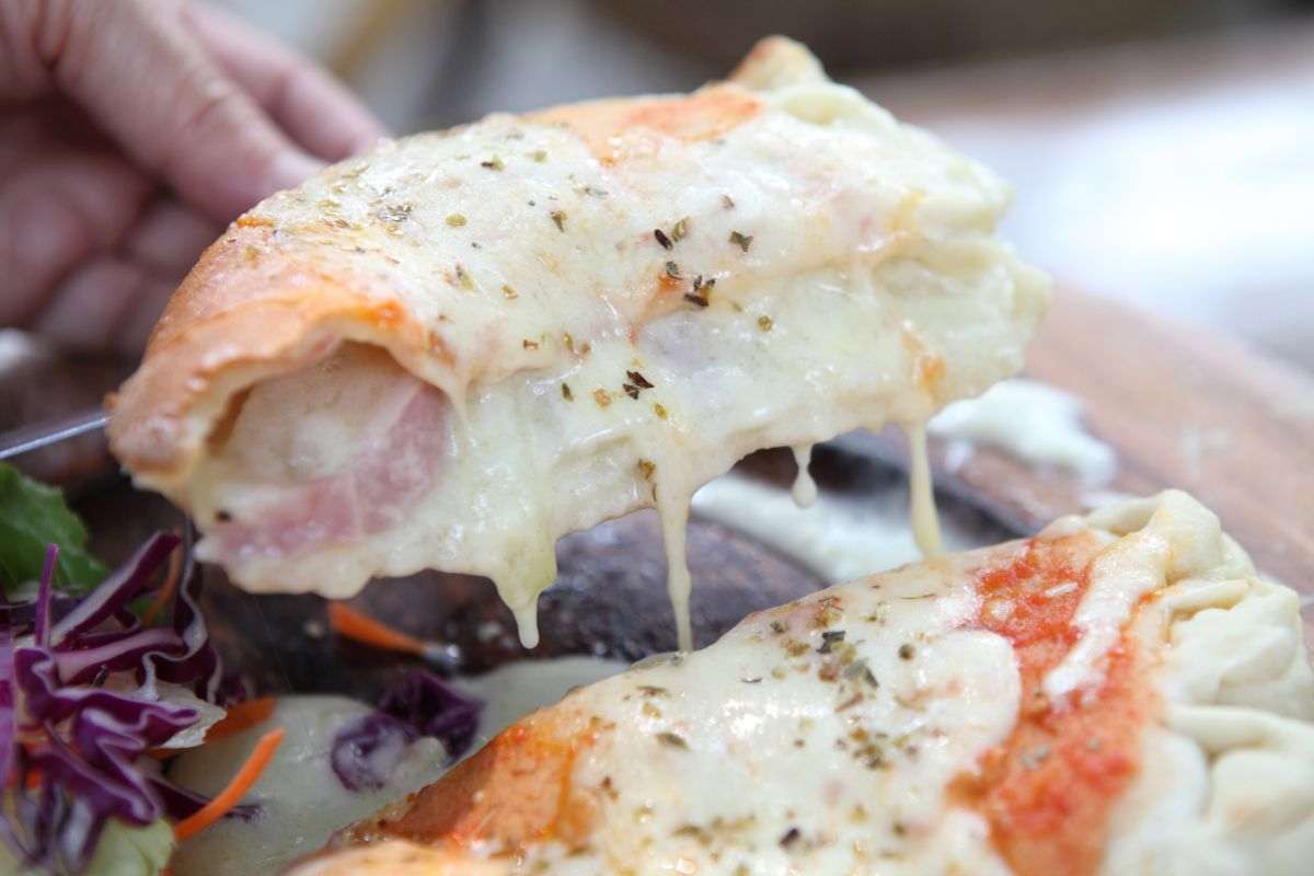 mano che impugna una fetta di pizza