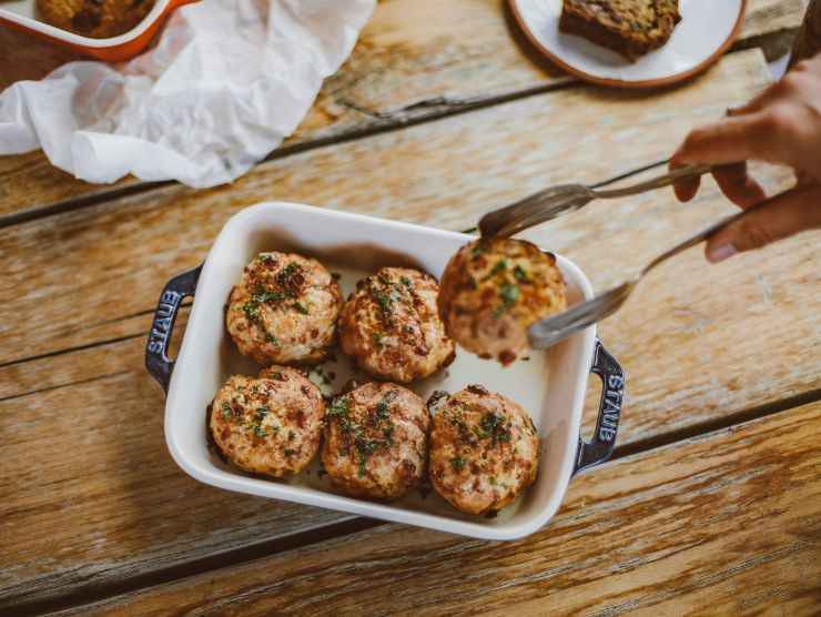 pinza che prende una polpetta da una teglia